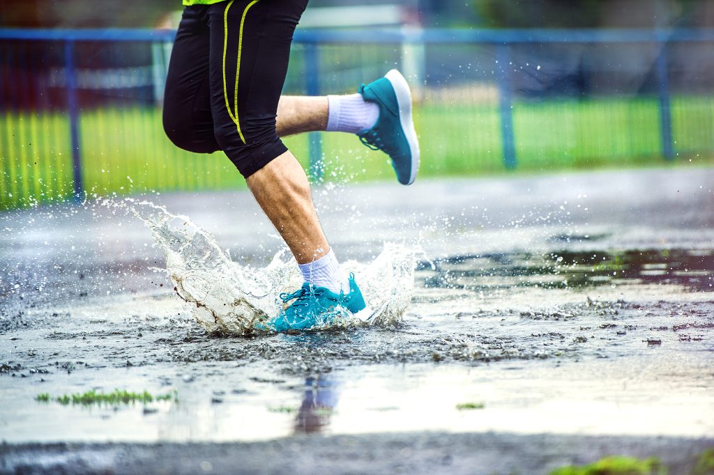 Detail of man running in rainy weather