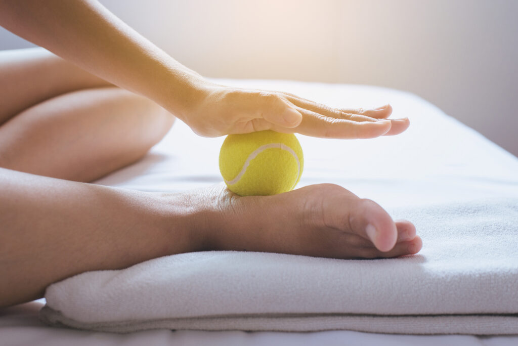 Foot Soles Massage,woman Hands Giving Massage With Tennis Ball T